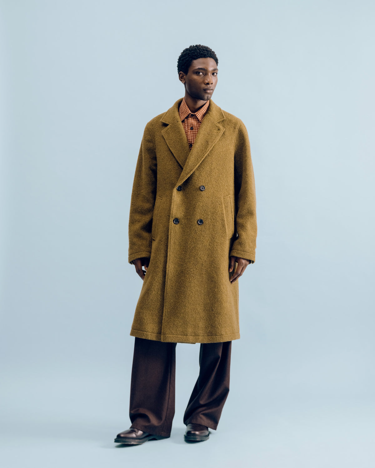 A moss green Tamworth double breasted overcoat with a rust check Corby shirt and chestnut flannel Orsman trousers