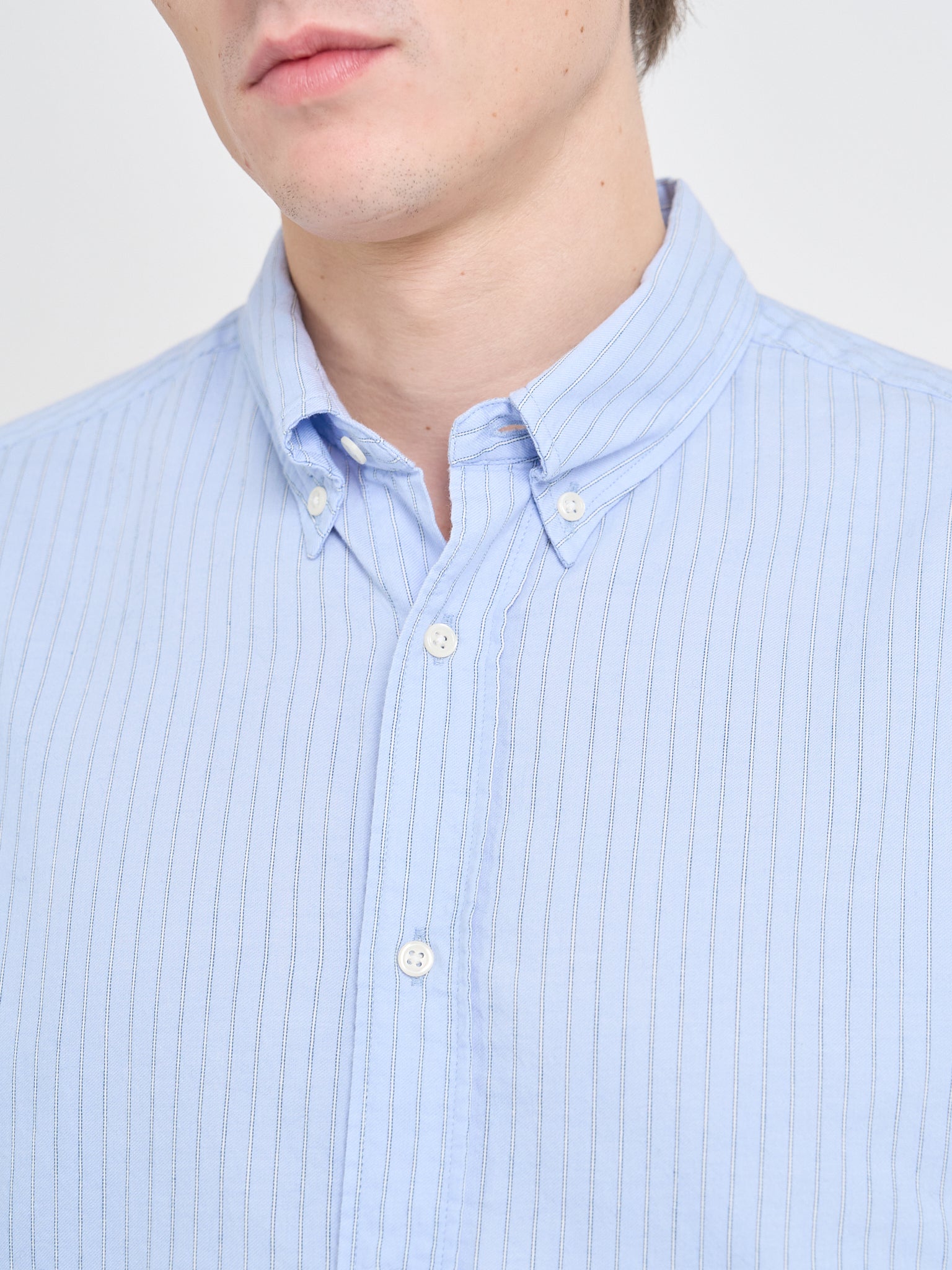 Close up collar shot of model wearing Oliver Spencer Men&#39;s Pale Blue Pinstripe Organic Cotton Button-Down Shirt