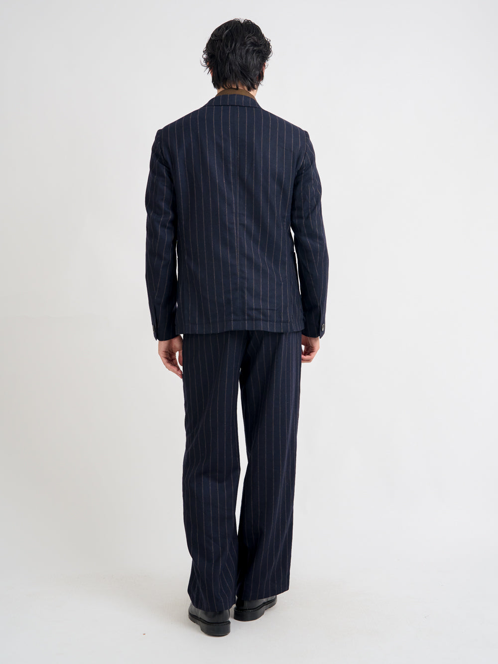 Back shot of model wearing Oliver Spencer Men's Unstructured Peak Lapel Navy Striped Jacket