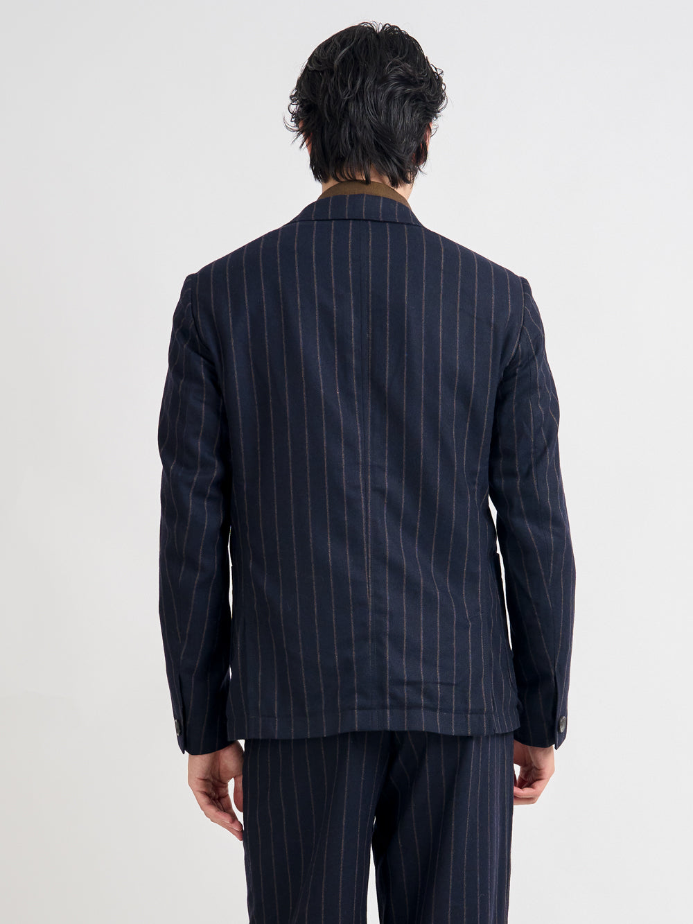 Close up back shot of model wearing Oliver Spencer Men's Unstructured Peak Lapel Navy Striped Jacket