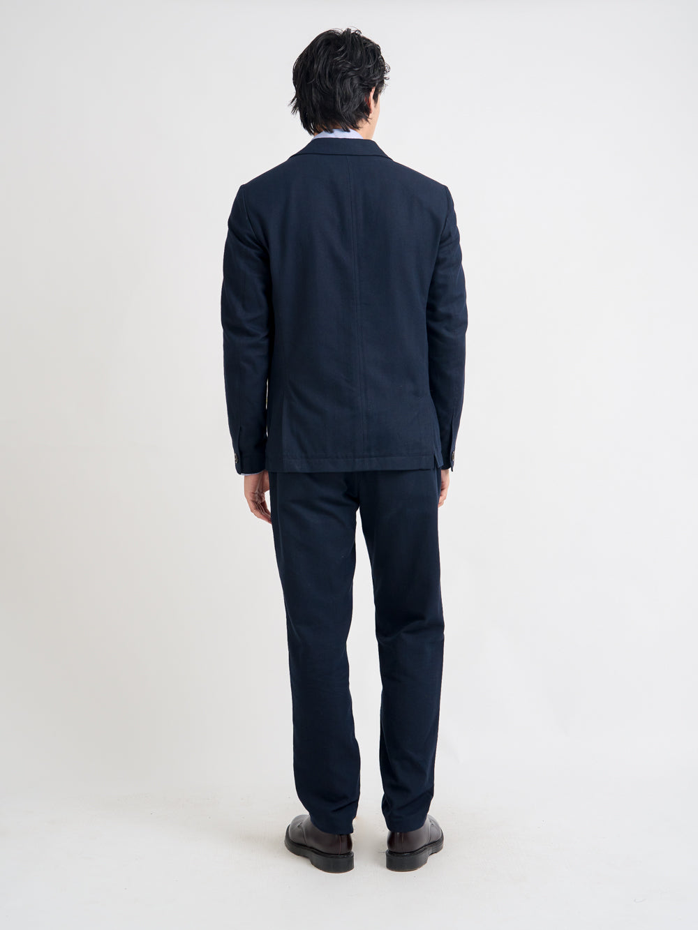 Back shot of model wearing Oliver Spencer Men's Unstructured Peak Lapel Navy Cotton Jacket