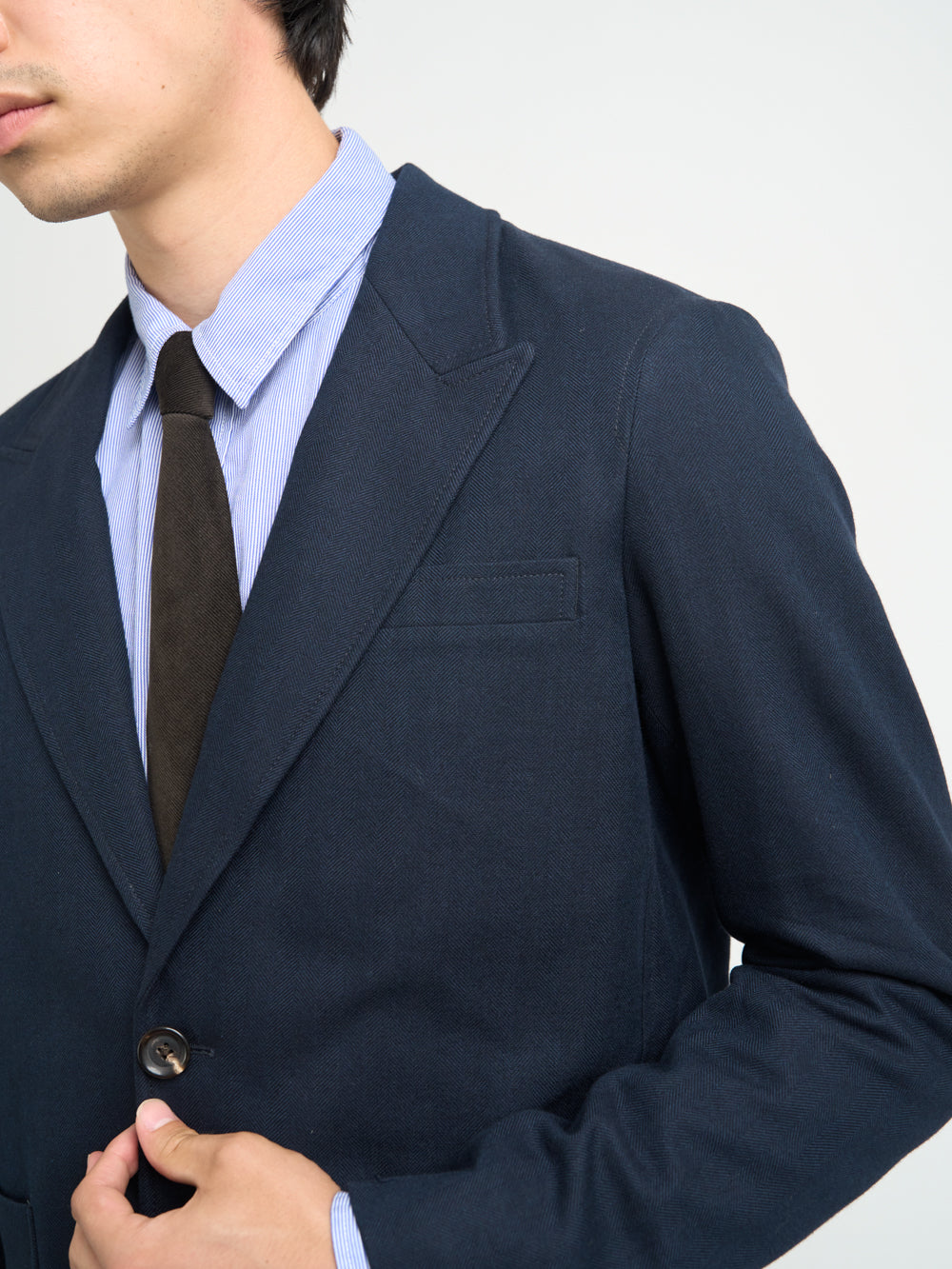 Up close collar shot of model wearing Oliver Spencer Men's Unstructured Peak Lapel Navy Cotton Jacket