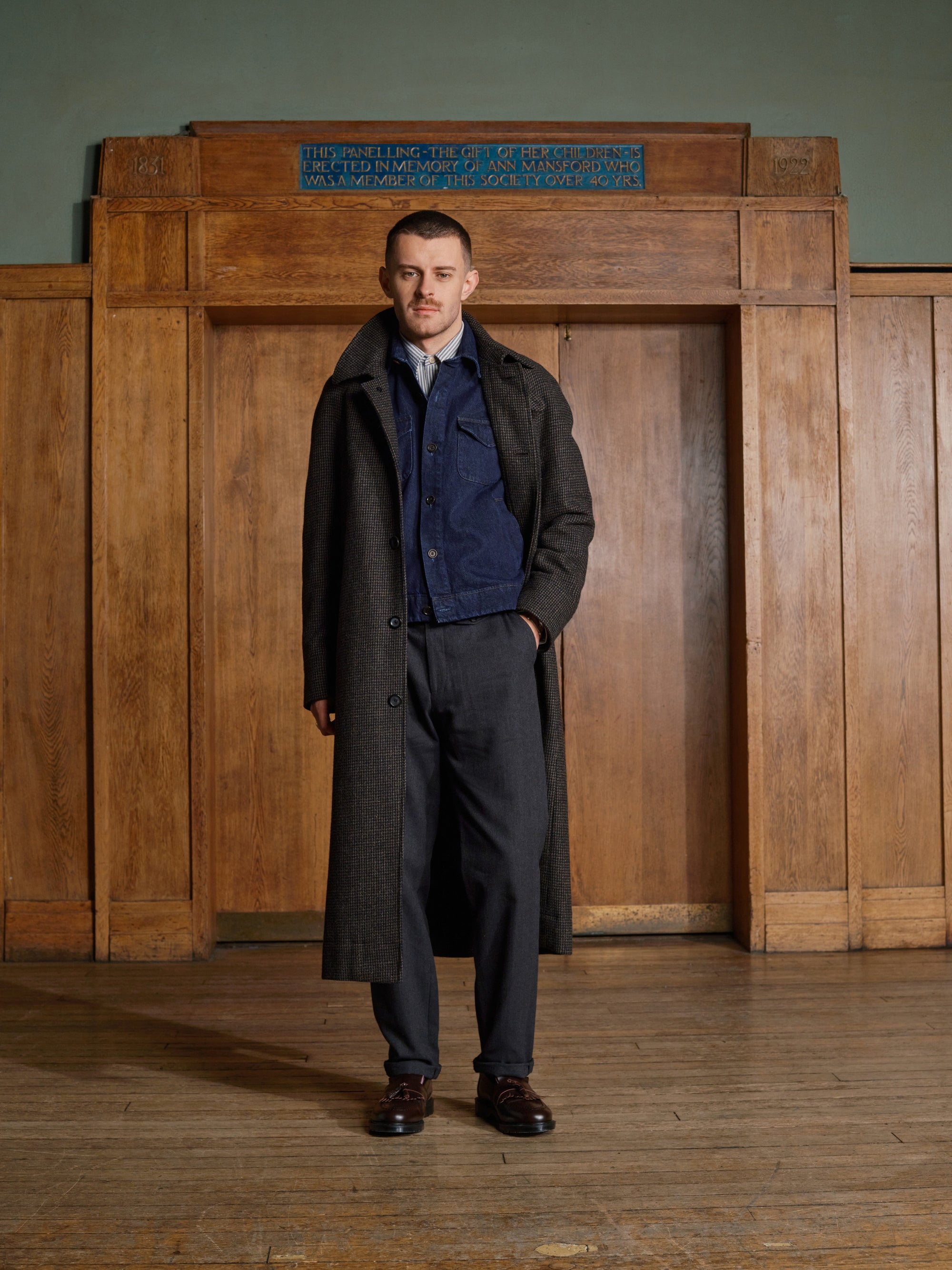 Model in a long coat over a denim jacket