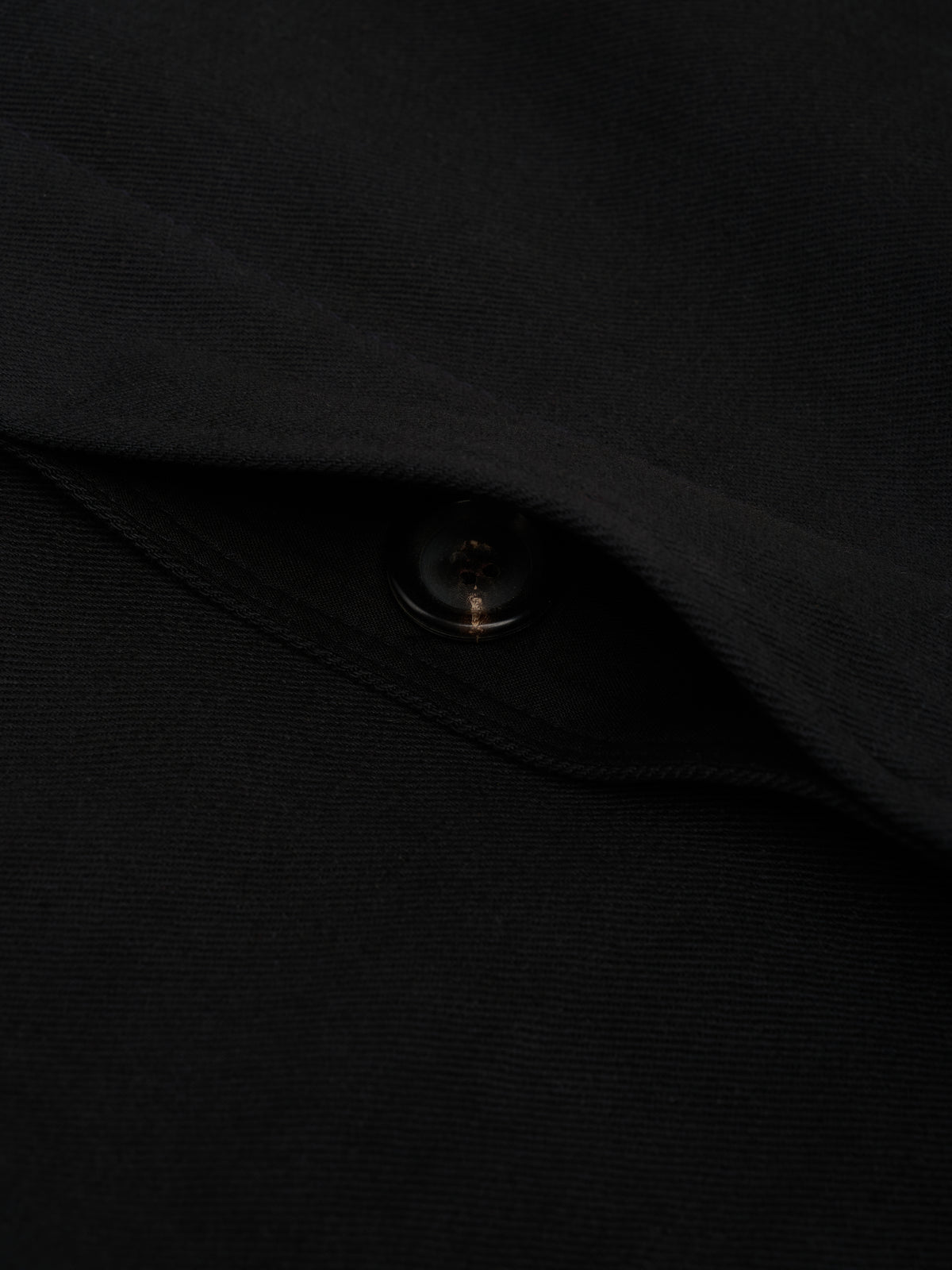 Pocket. A pocket flap lifted to show a button underneath.