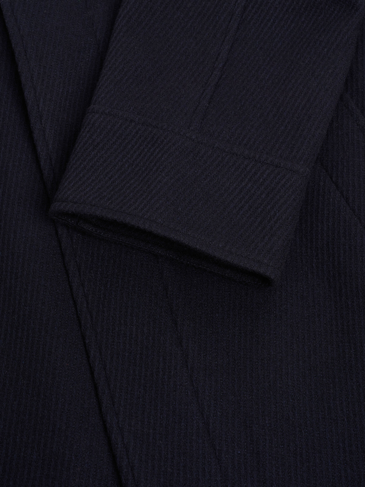 Cuff. No button, so the sleeve finishes in one clean line.