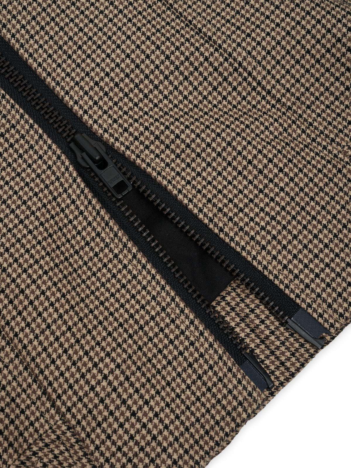 Zip. The bottom of the open zip, with two end stops.