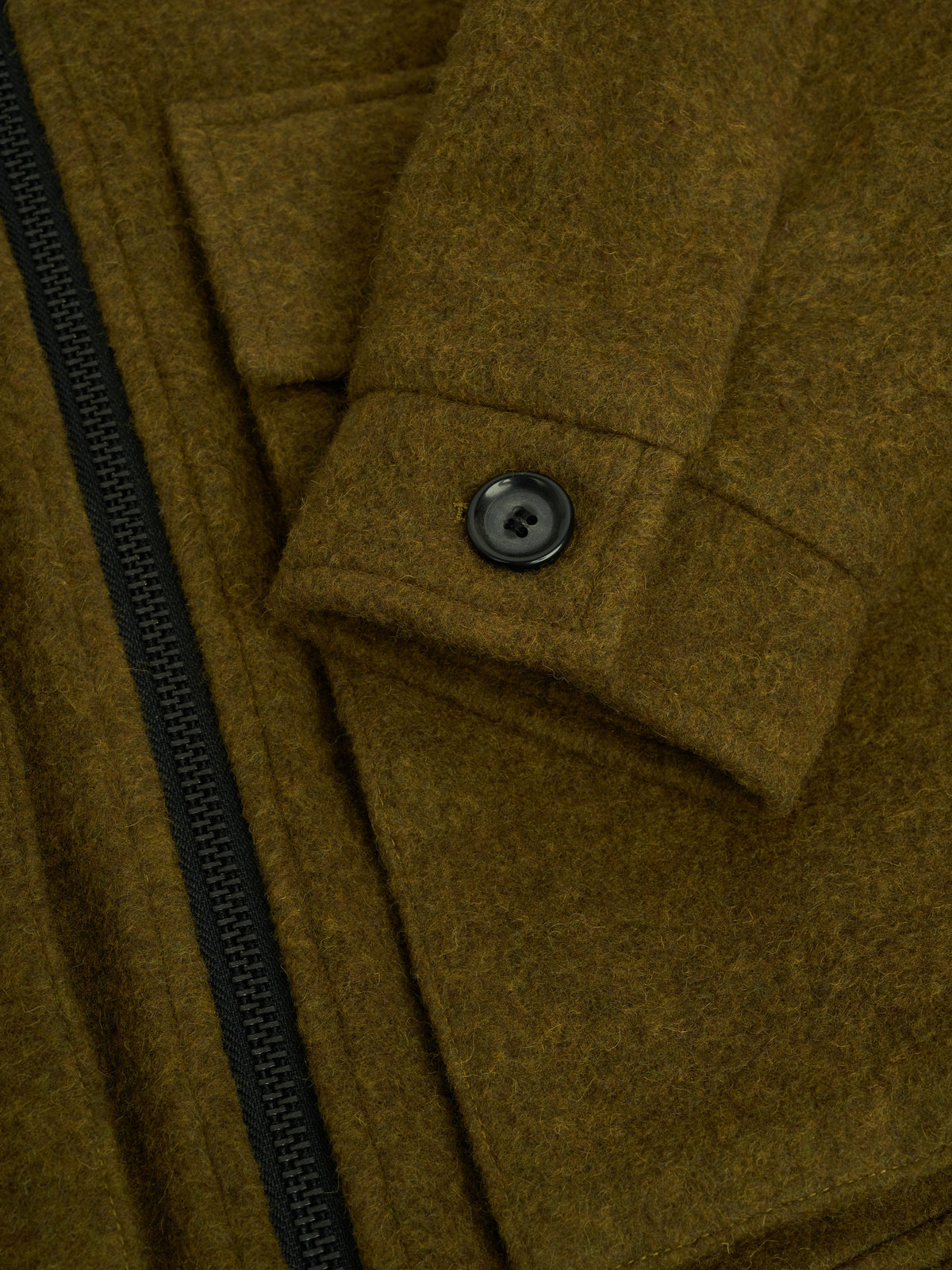 Cuff. A cuff with one black button beside the zip.