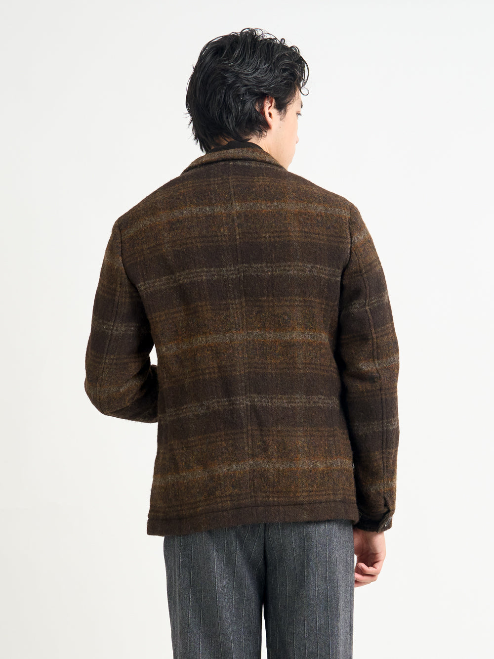 Closer up back shot shot of model wearing Oliver Spencer Men's Unstructured Notch Lapel Brown Plaid Jacket