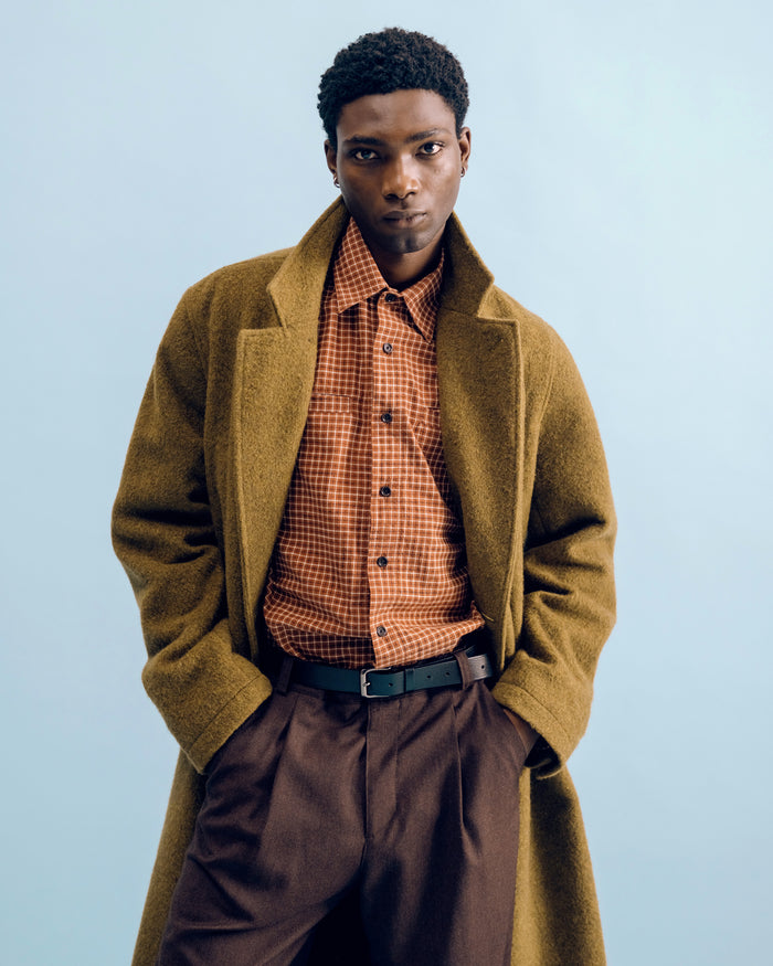 Close crop of a moss green Tamworth double breasted overcoat over a rust check Corby shirt